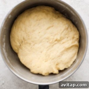 Dough being kneaded in a stand mixer with a dough hook.