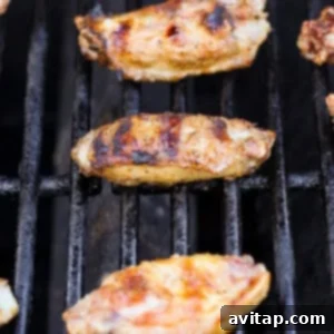 Grilled chicken wings on a barbecue grill with grill marks visible.