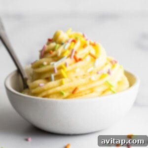 Strawberry Dole Whip 5 A bowl of classic pineapple Dole Whip with sprinkles and a spoon, inviting you to try.