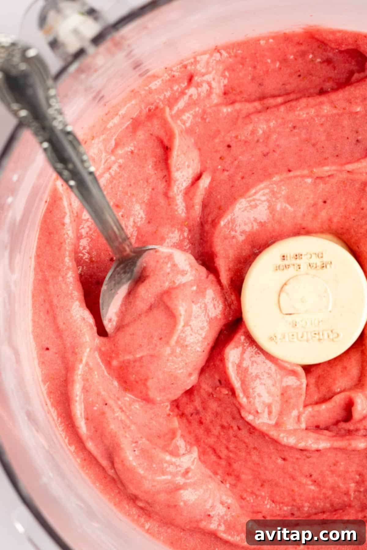 Strawberry Dole Whip 6 Top-down view of a bowl of fresh strawberry puree with a measuring spoon dipped inside, showing the perfect texture.
