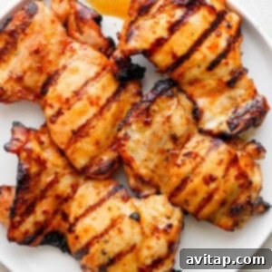 Chicken thighs grilling on an outdoor grill.