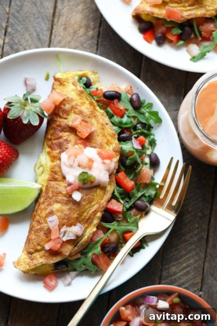 A close-up of a vibrant veggie omelette garnished with fresh parsley and black beans, ready to be enjoyed.