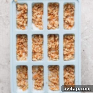Inserting popsicle sticks into molds after adding the topping.