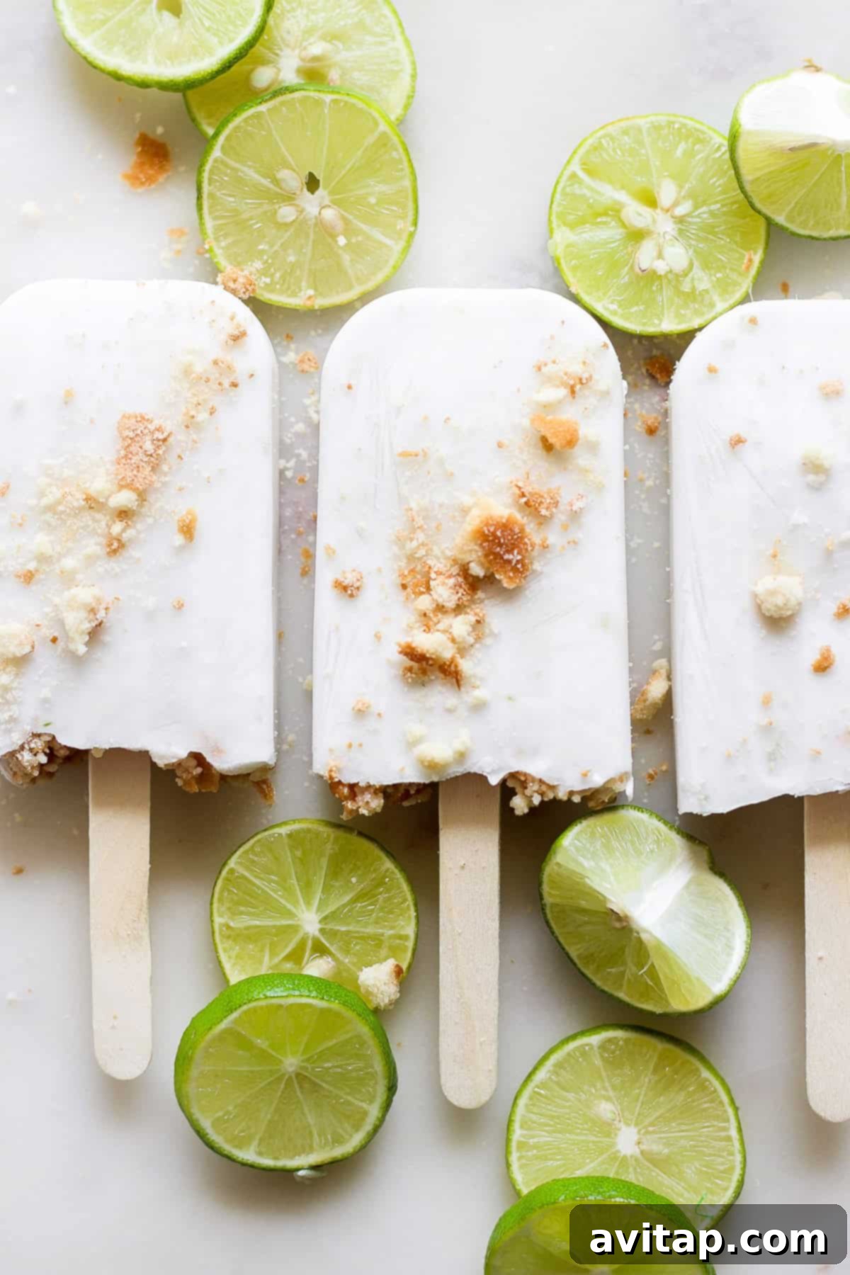 A tray of Coconut Key Lime Pie Popsicles being removed from their molds.
