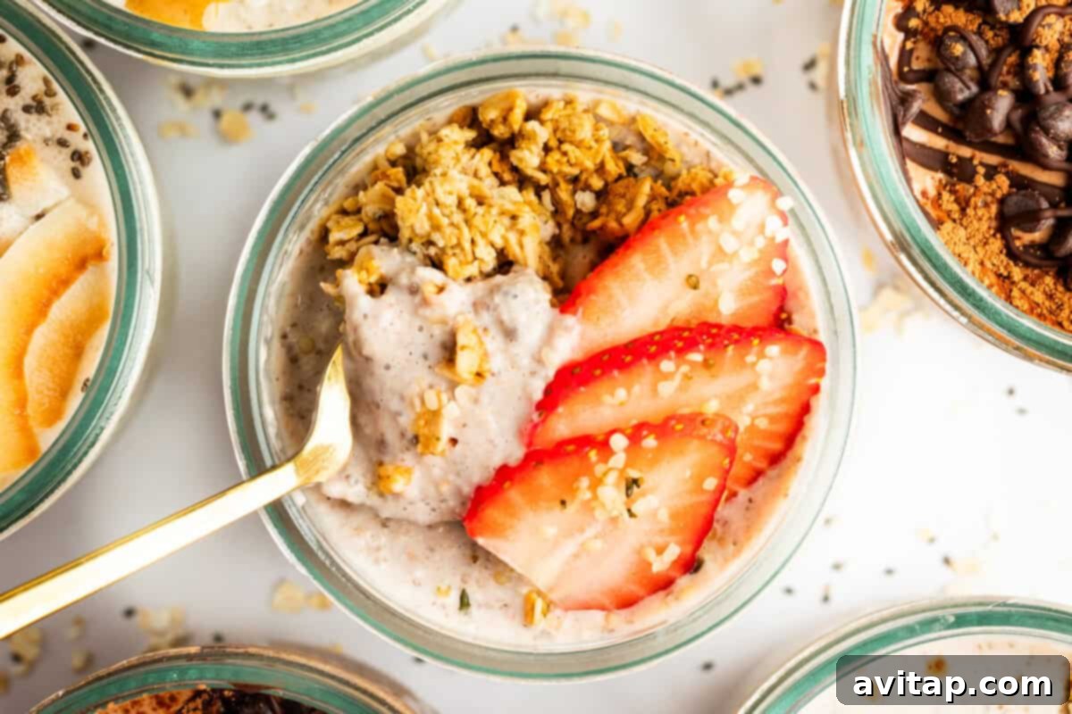 A bowl of oatmeal topped with sliced strawberries, granola, and a gold spoon placed in it, showcasing a fresh and appealing breakfast.