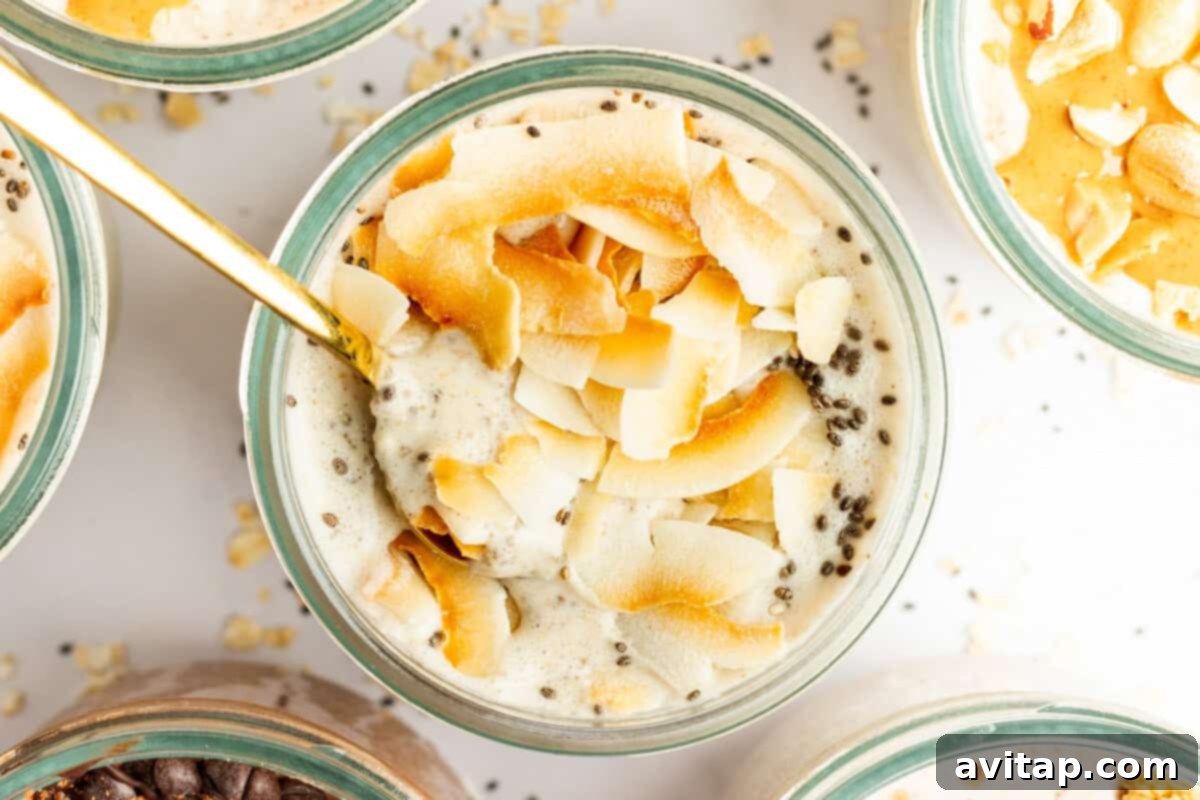 A glass bowl filled with a creamy mixture topped with toasted coconut flakes and chia seeds, with a gold spoon inserted into it, promising a tropical and satisfying treat.
