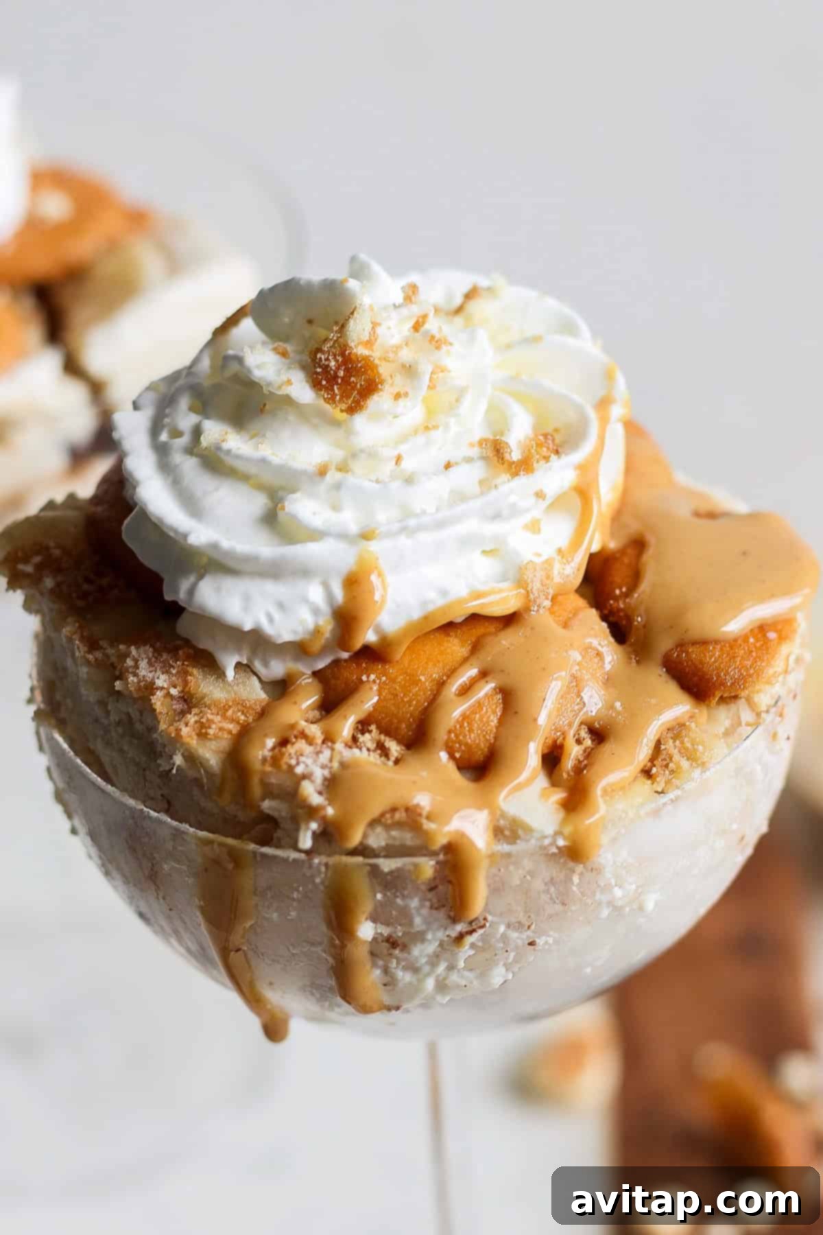 Peanut Butter Banana Icebox Delight 2 A dessert in a glass featuring layers of caramel, ice cream, whipped cream, and crumbled cookies on top, reminiscent of a peanut butter banana ice box cake.