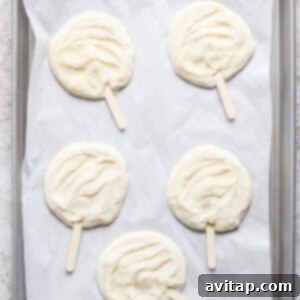 Delicious Homemade Dilly Bars 8 Four raw popsicle-shaped dough pieces on parchment paper in a gray baking tray.