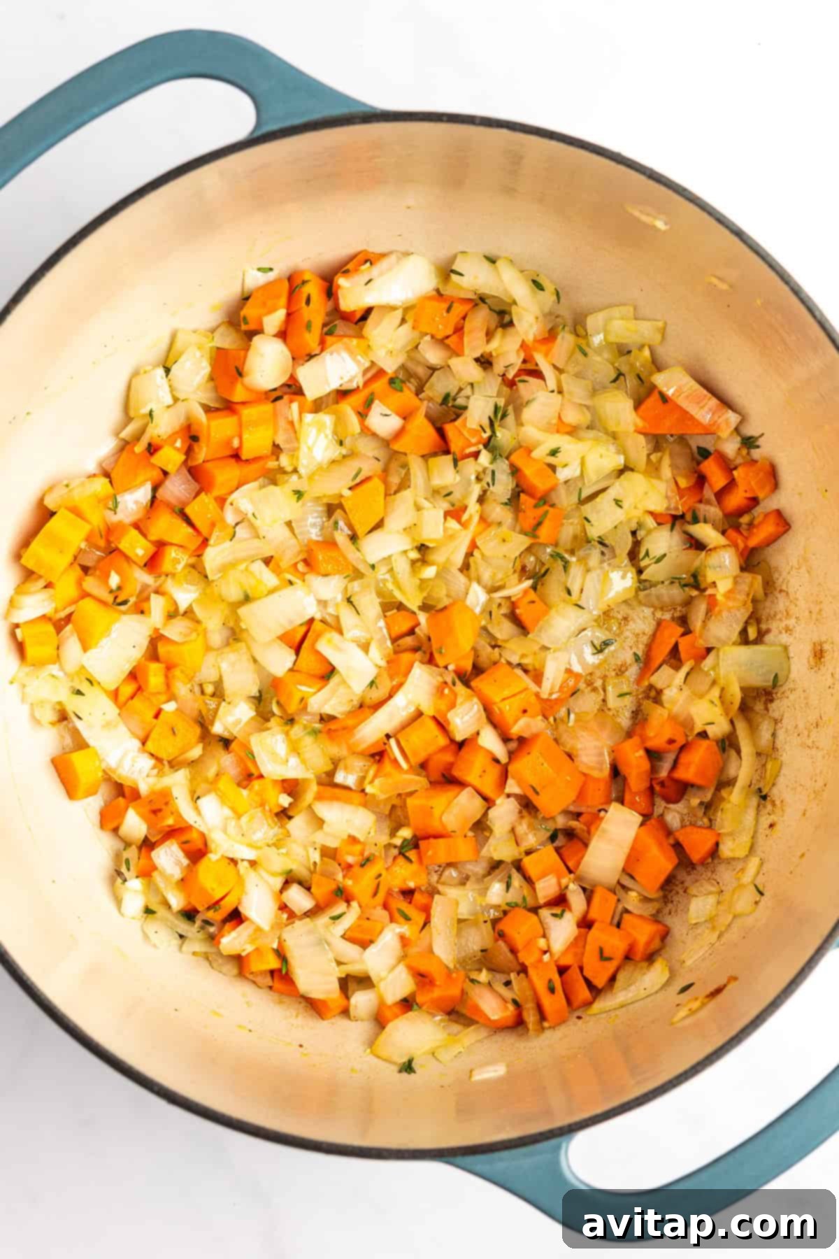 Quick & Creamy Pumpkin Soup 5 A pot containing sautéed diced onions and carrots.