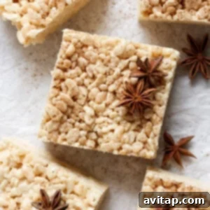 Square rice crispy treats with a dusting of spices and garnished with star anise, arranged on a parchment paper surface.