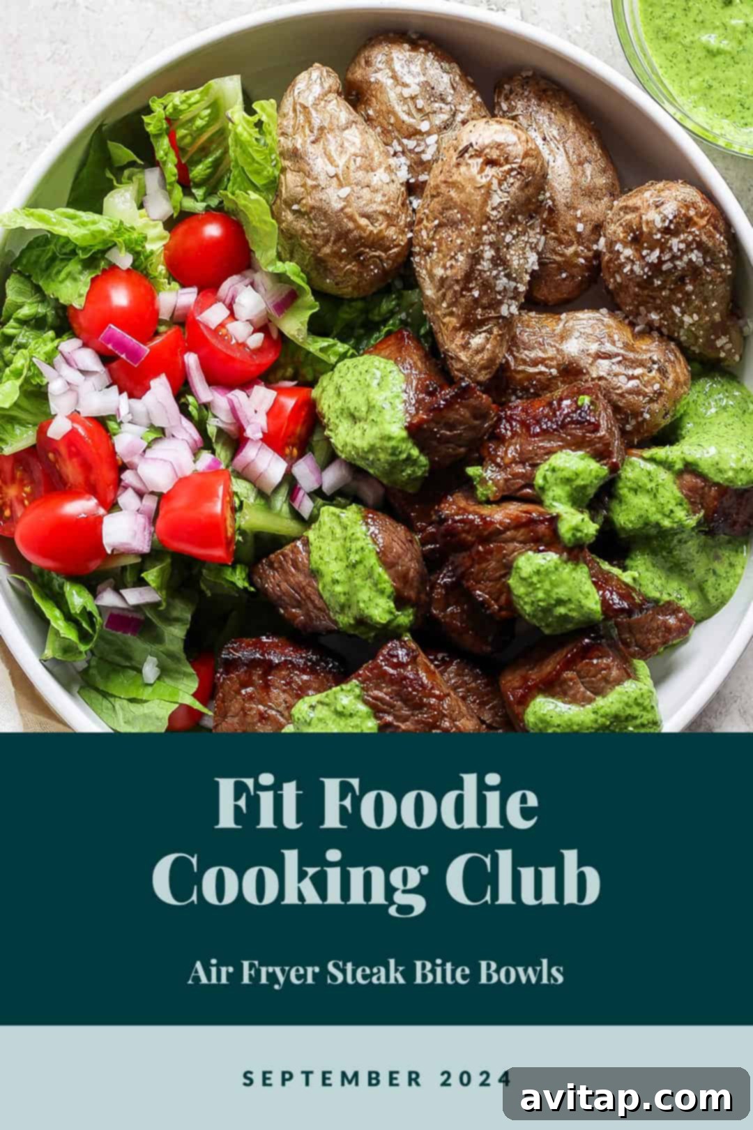 A vibrant bowl featuring succulent steak bites, golden roasted potatoes, a fresh green salad, and drizzled with a rich green sauce. The image also displays text: 'Fit Foodie Cooking Club - Air Fryer Steak Bite Bowls - September 2024.'