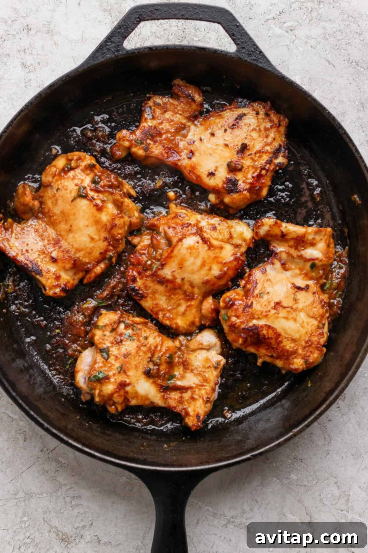 A cast-iron skillet filled with perfectly seared, golden-brown miso chicken thighs.