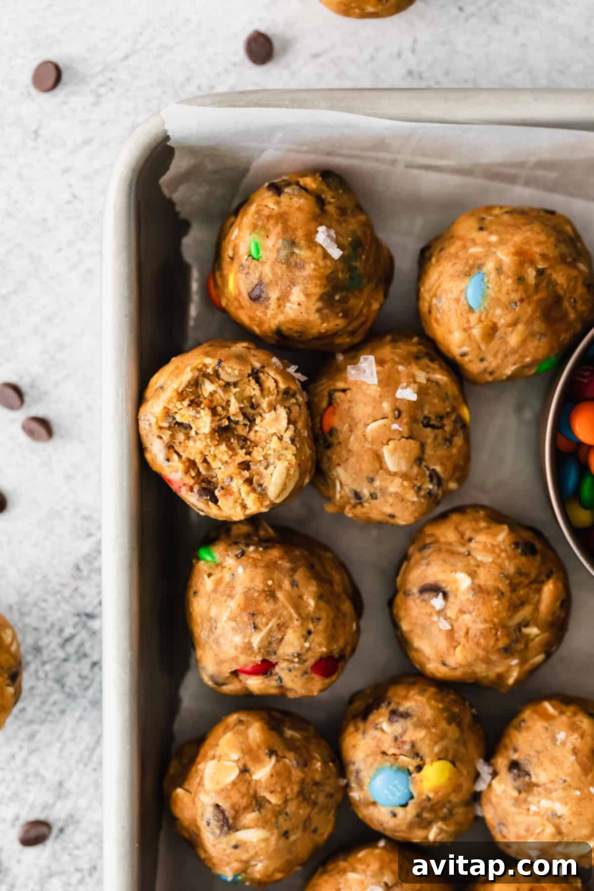 M&m energy bites in a baking pan with a bowl of m&m's.