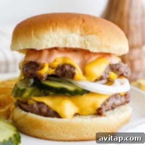 A close-up image of a gourmet burger featuring a juicy patty, melted cheese, fresh lettuce, and vibrant yellow corn kernels, all served on a toasted bun.