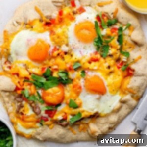 A rustic breakfast galette with sunny-side-up eggs, melted cheese, red peppers, and fresh parsley, next to a knife and a bowl of chopped herbs.