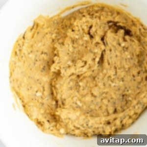 Creamy peanut butter, chia seeds, and oat mixture expertly combined in a white bowl, showing its ideal pliable consistency for shaping.
