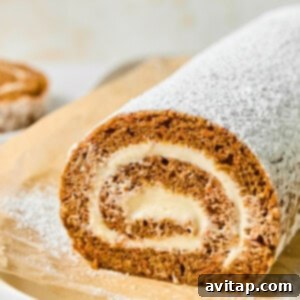 A rolled cake dusted with powdered sugar on parchment paper, showing a spiral of cream filling.