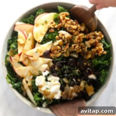 A beautifully composed festive Thanksgiving salad, showcasing a vibrant mix of fresh, crisp kale, bright apple slices, and crunchy walnuts, all harmoniously combined to create a delightful and seasonal culinary experience.