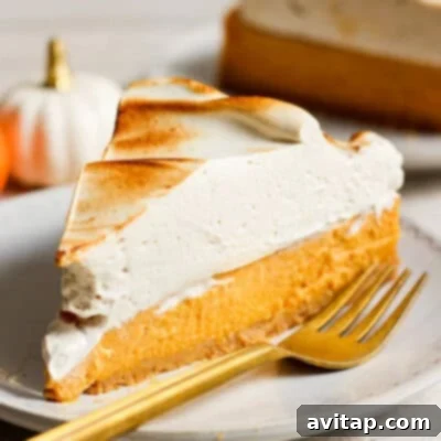 A perfect slice of high-protein cottage cheese pumpkin cheesecake, elegantly garnished with a delicate dollop of whipped cream, resting on a white plate with a fork, invitingly ready to be savored.