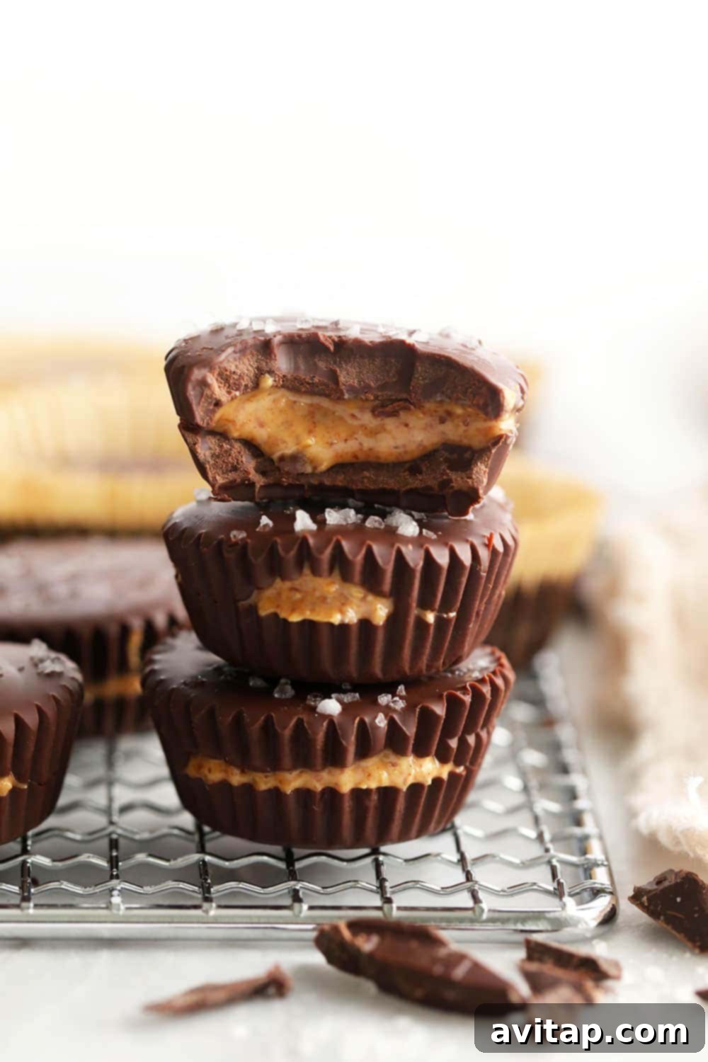 Homemade almond butter cups are a simple dessert that will satisfy your sweet tooth craving! Plus, these almond butter cups are topped with flakey sea salt. stacked almond butter cups with flaky sea salt on top