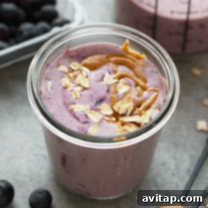 A peanut butter and jelly protein smoothie in a mason jar.