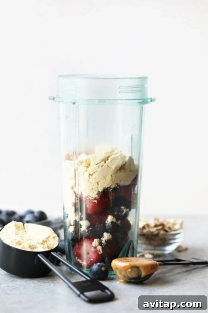 Ingredients for PB&J smoothie being blended in a high-speed blender.