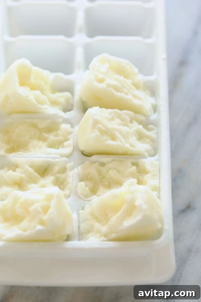 This Healthy Banana Protein Shake is packed with a short list of real ingredients and blended together to perfection! Boasting 16 g of protein per serving and oh so flavorful, this protein shake recipe will fuel your body post-workout or or as a sweet treat. Enjoy! Close-up shot of frozen Greek yogurt cubes in an ice cube tray, ready for making creamy protein shakes.