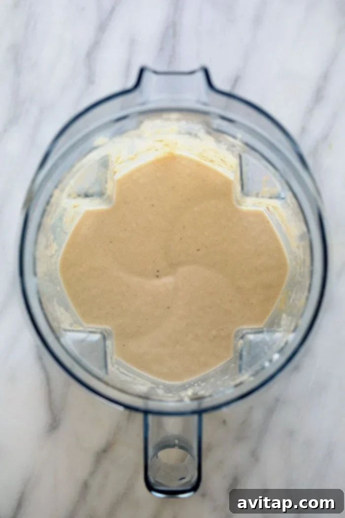 This Healthy Banana Protein Shake is packed with a short list of real ingredients and blended together to perfection! Boasting 16 g of protein per serving and oh so flavorful, this protein shake recipe will fuel your body post-workout or or as a sweet treat. Enjoy! A high-speed blender actively mixing the ingredients for a healthy banana protein shake, showing the creamy texture forming.