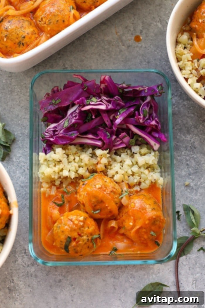 Red Coconut Curry Meatballs and Cauliflower Rice in a glass meal prep container, ready for the week.