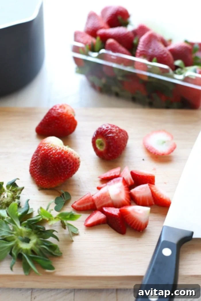 Fresh, vibrant strawberries on a wooden cutting board, ready for preparing a delicious compote.