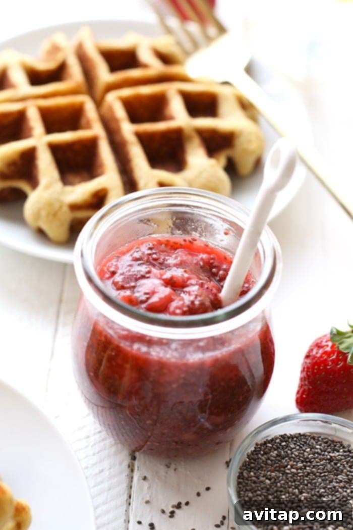 Homemade strawberry chia compote, rich in color and texture, stored in a glass jar.