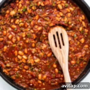 Sauce and beans simmering in pan.