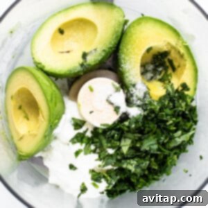 Avocado crema blending in a food processor.