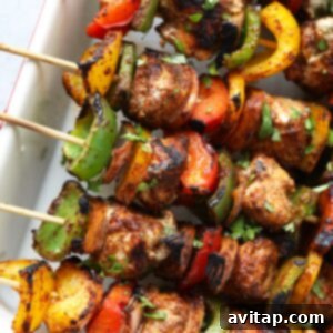 Grilled chicken fajita kebabs on skewers with peppers and onions.