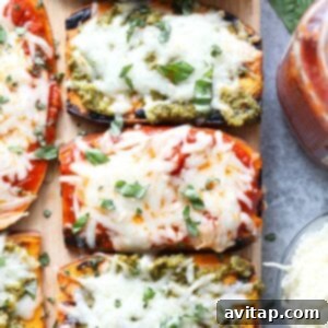 Roasted sweet potato skewers with pesto and basil arranged on a cutting board.