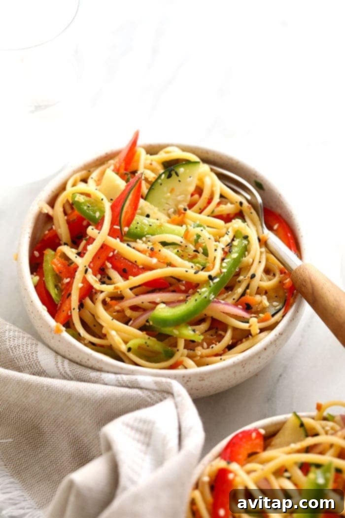 Vibrant Rainbow Sesame Noodle Salad in a large serving bowl, showcasing colorful vegetables and noodles.