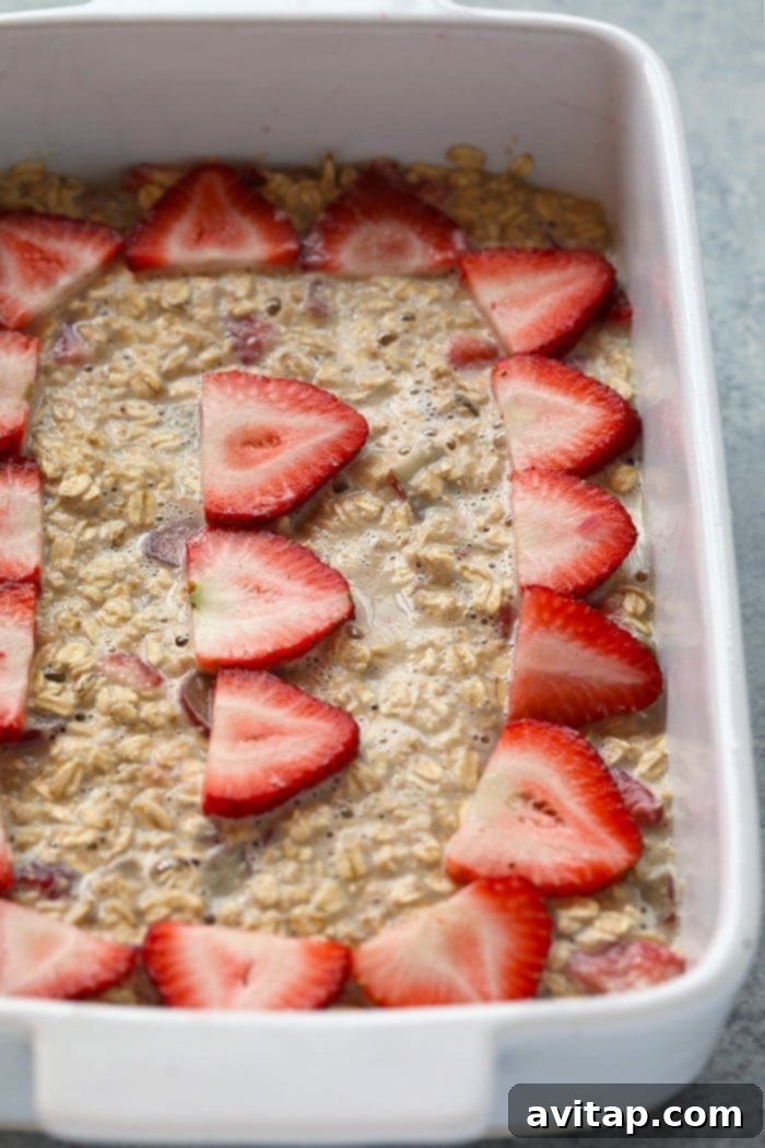 Strawberry rhubarb oatmeal bake prepared in a casserole dish, ready to be baked in the oven for a delicious breakfast.