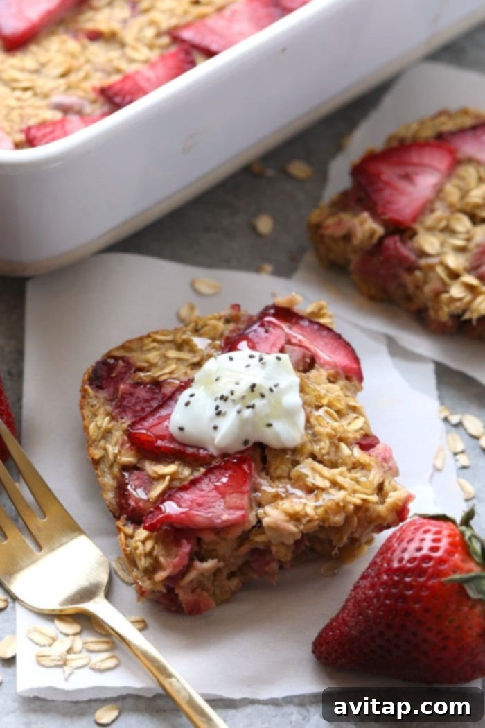 A perfectly portioned slice of golden-baked strawberry rhubarb oatmeal, ready to be served and enjoyed, showcasing its healthy and delicious appeal.