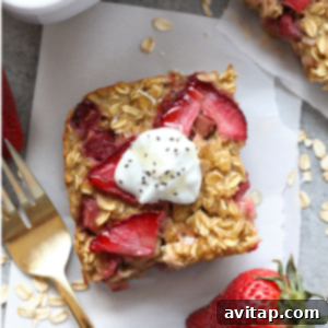 A square image depicting a delicious serving of strawberry rhubarb baked oatmeal, garnished with fresh berries.