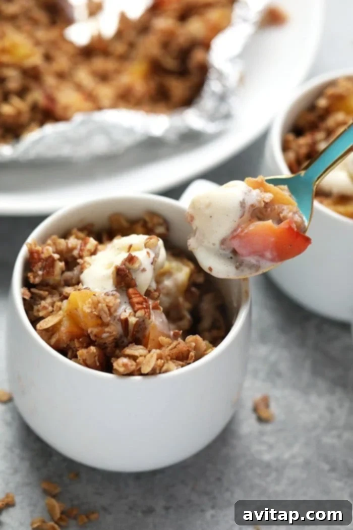 Peach crumble in coffee mug with spoon.