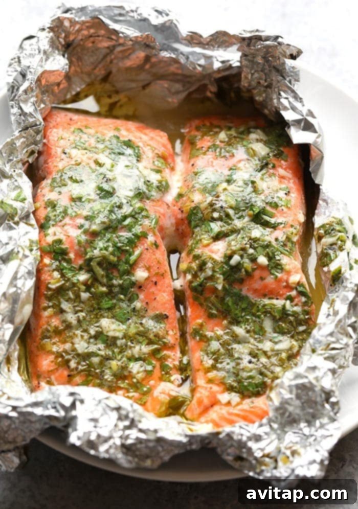 Grilled salmon with fresh herbs in a foil packet, ready for the BBQ.