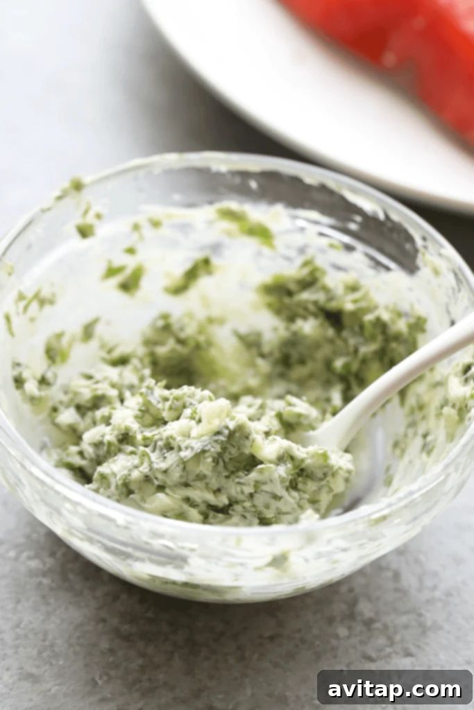 A bowl of freshly prepared herbed butter, ready to be spread over salmon.