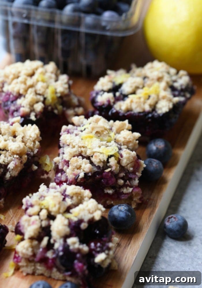 Beautifully arranged Lemon Blueberry Crumble Bars on a wooden cutting board, ready to be served.