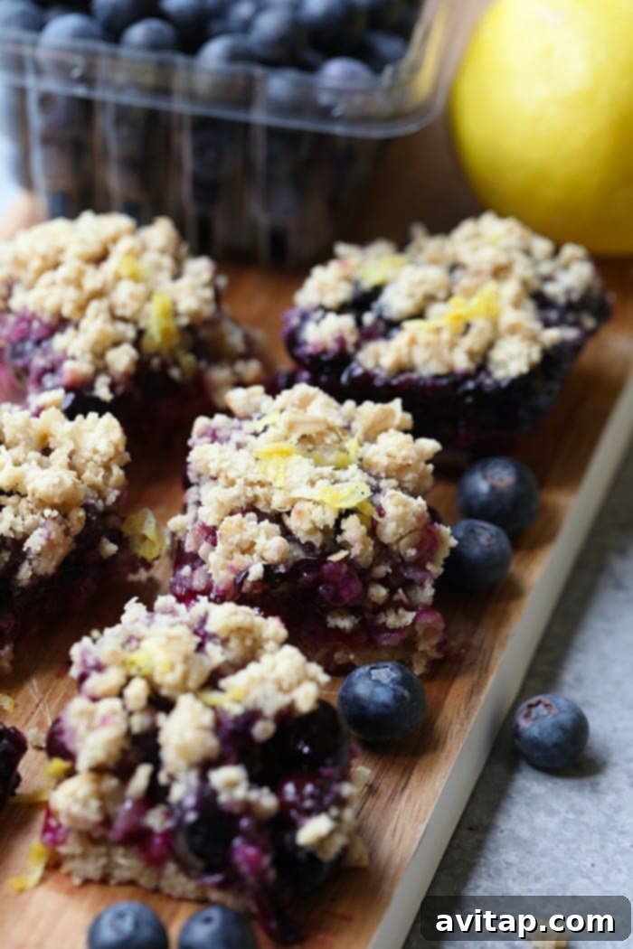 Three Lemon Blueberry Crumble Bars arranged neatly on a white plate, ready for serving.