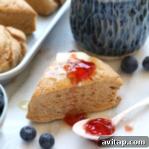 Honey whole wheat scones with blueberries and jam on a tray, ready to be served.