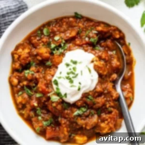 Hearty Pumpkin Chili 3 A vibrant bowl of turkey pumpkin chili, garnished with fresh toppings, ready to be enjoyed.