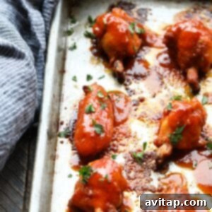 BBQ chicken wings being baked on a sheet, sizzling and browning in the oven.