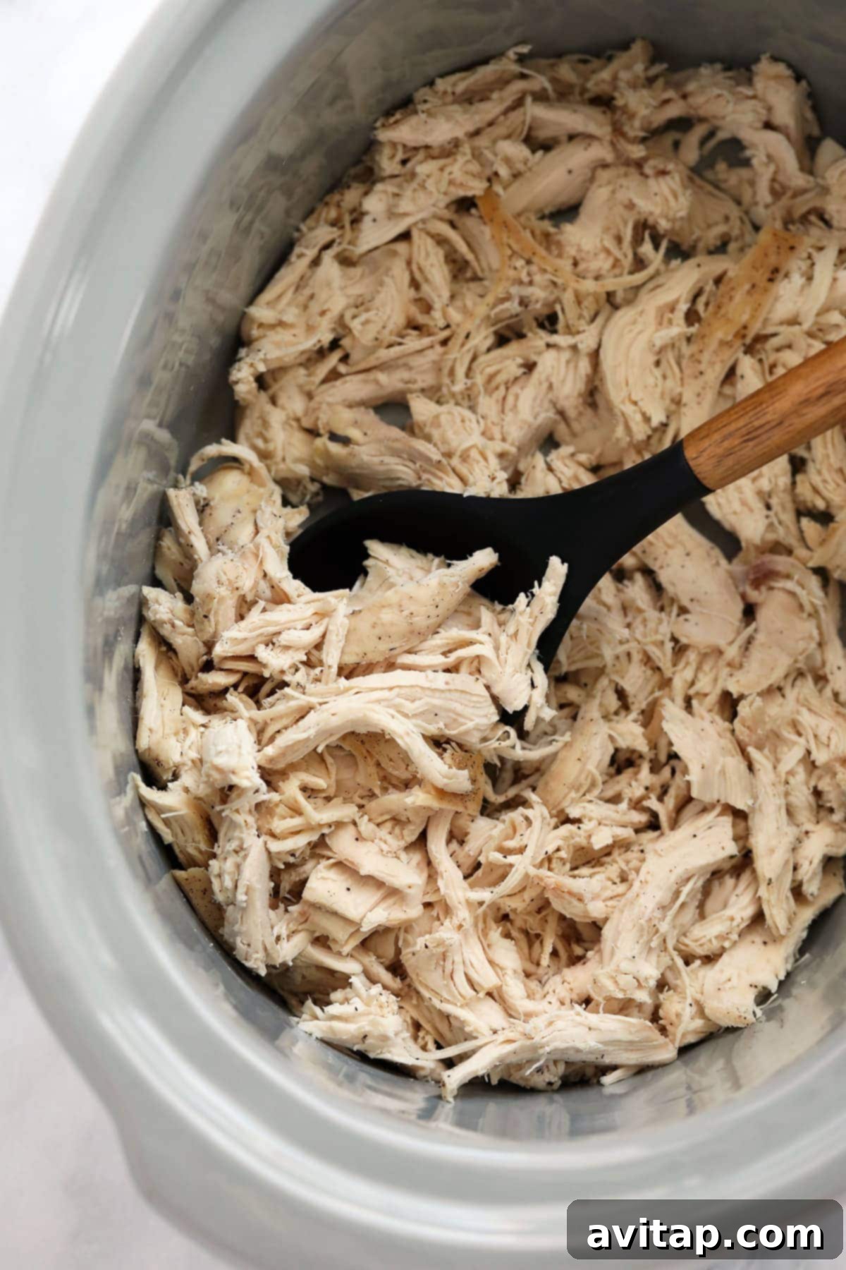 Perfectly cooked shredded chicken in a slow cooker, ready to be served or used in recipes.