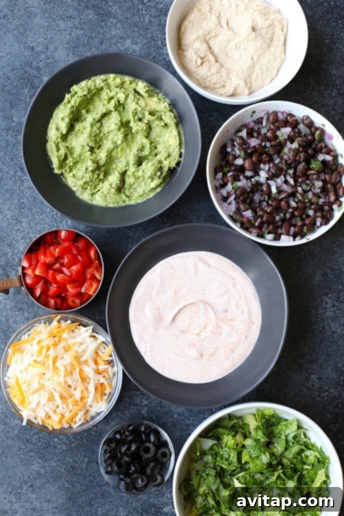 Fresh ingredients laid out in bowls for Healthy 7 Layer Greek Yogurt Taco Dip preparation
