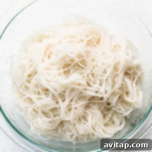 Freshly cooked thin rice noodles, perfectly al dente and ready to be added to the curry soup, preventing them from becoming mushy.